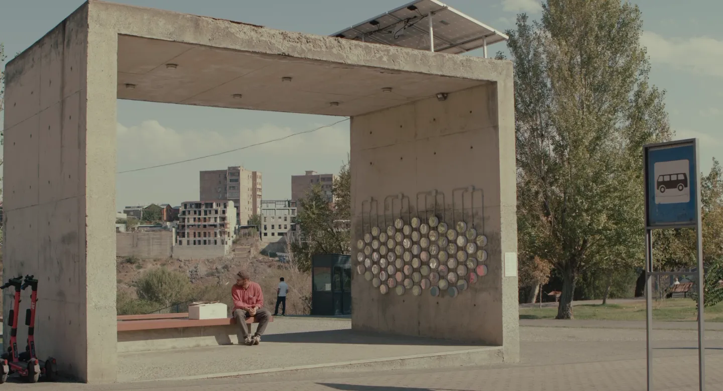 Concrete bus shelter with a man sitting inside